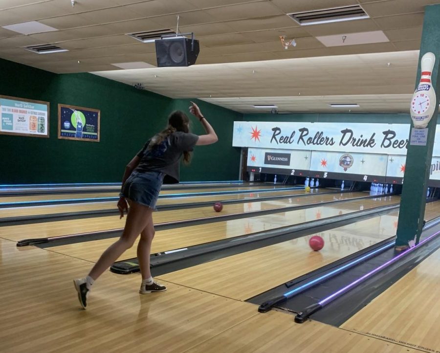 Freshman Audrey Martin rolls the ball down the lane May 23. The track team had team bonding event at Park Tavern.