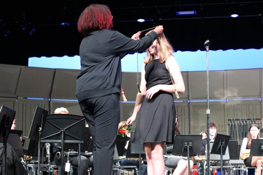 Senior Amira Abdiraham gives Greta Runyan a cord representing her participation in band. Each senior in band received a cord to wear at graduation. 