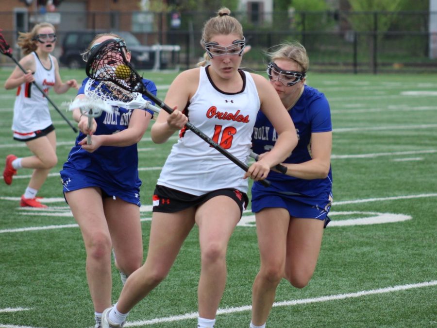 Senior Anna McCallon defends the ball May 12. Girls’ lacrosse won their senior night game with a 10-8 win against Holy Angels.