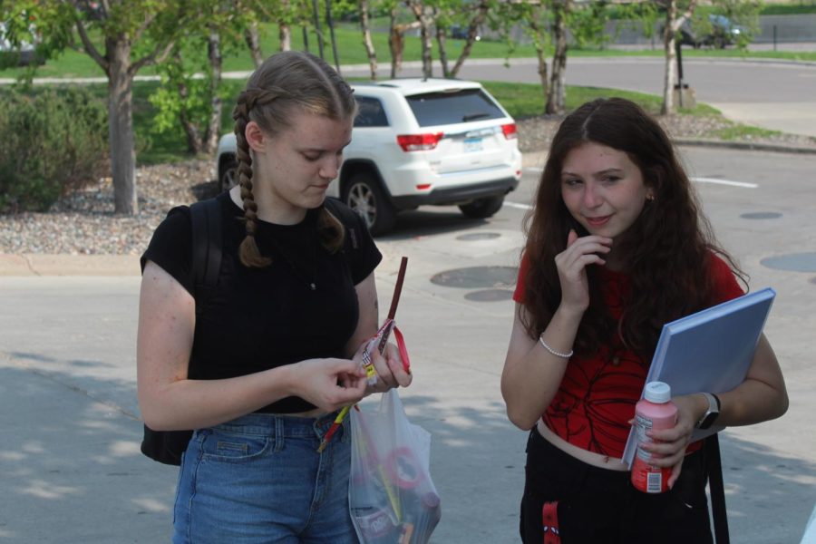 Senior Abigail Baudhuin and freshman Alyssa Johannes eat food near a gas station May 22. At the final Girls United meeting, the club relaxed and ate food while preparing for next year.