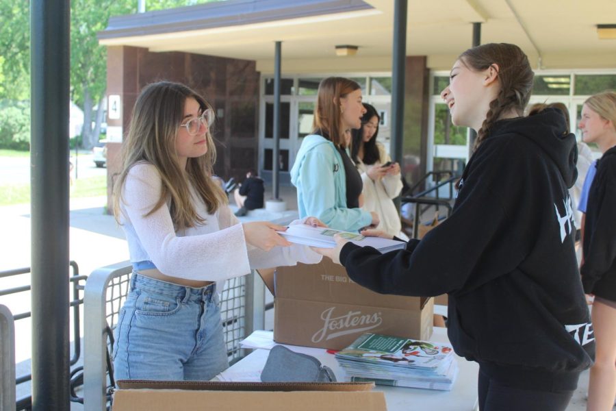 Junior Eliana Montero-Ward hands Lola Powers a yearbook during the final day of yearbook distribution. Distribution began May 22 and took place during lunches. 