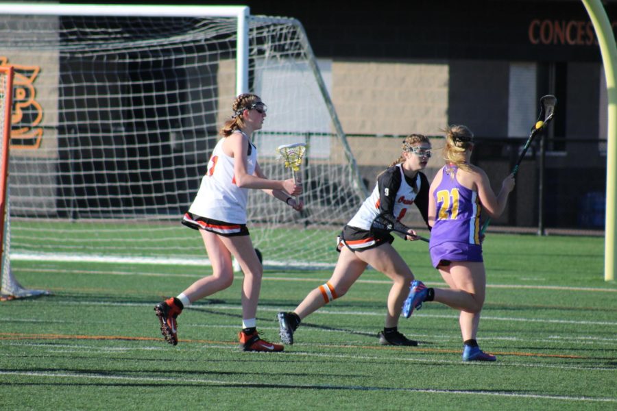 Juniors Madeline Anklam and Rylie Unangst defend against Waconia during their home opener May 2. Girls’ lacrosse closed off their home opener with a 14-1 win against Waconia.