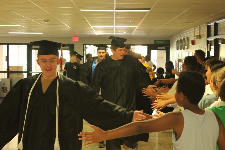 Park seniors walk through the doors of Aquila Elementary May 31. The seniors commemorated their graduation by holding a senior walk through elementary schools Wednesday.