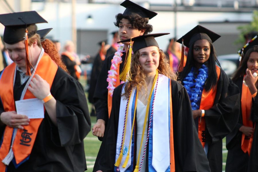 Graduating senior Sophia Earle walks across the football field to be seated June 6. The graduation ceremony began with the seniors lap around the field.
