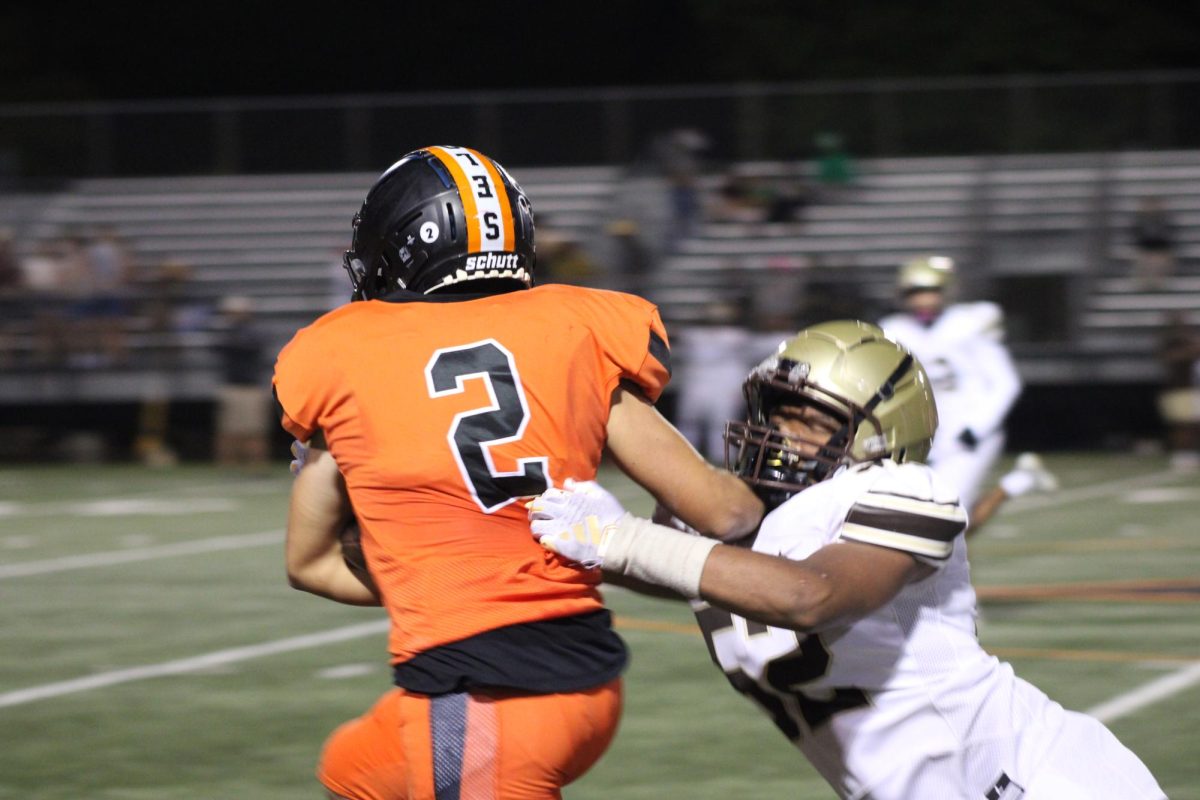 Sophomore Mason Helfmann pushes off an Apple Valley Eagles player in an attempt to get to the end zone Sept. 14. The game was held at the Nest against Apple Valley.