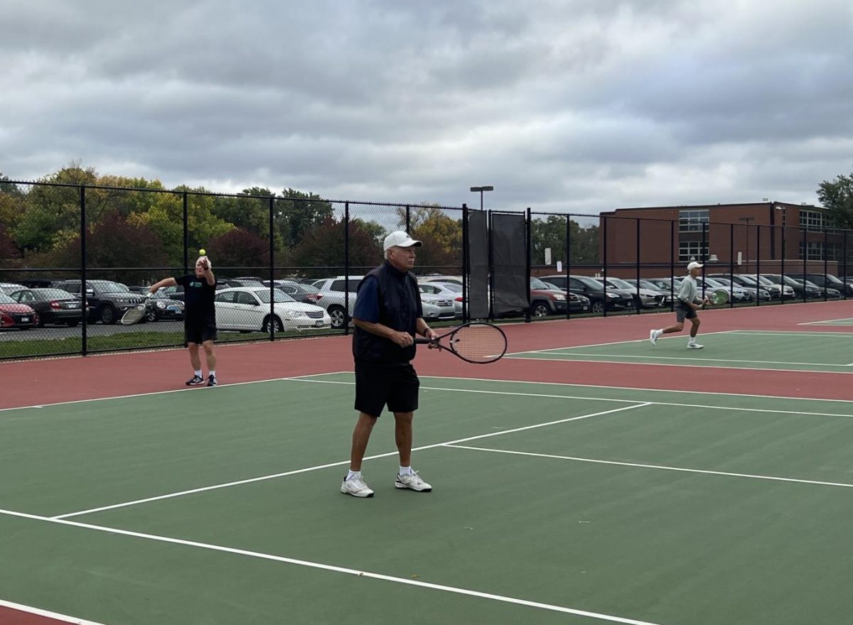 Senior+tennis+player+Micheal+Schneider+serves+ball+Oct.+4.+The+seniors+play+on+Parks+tennis+courts+a+few+times+a+week.+