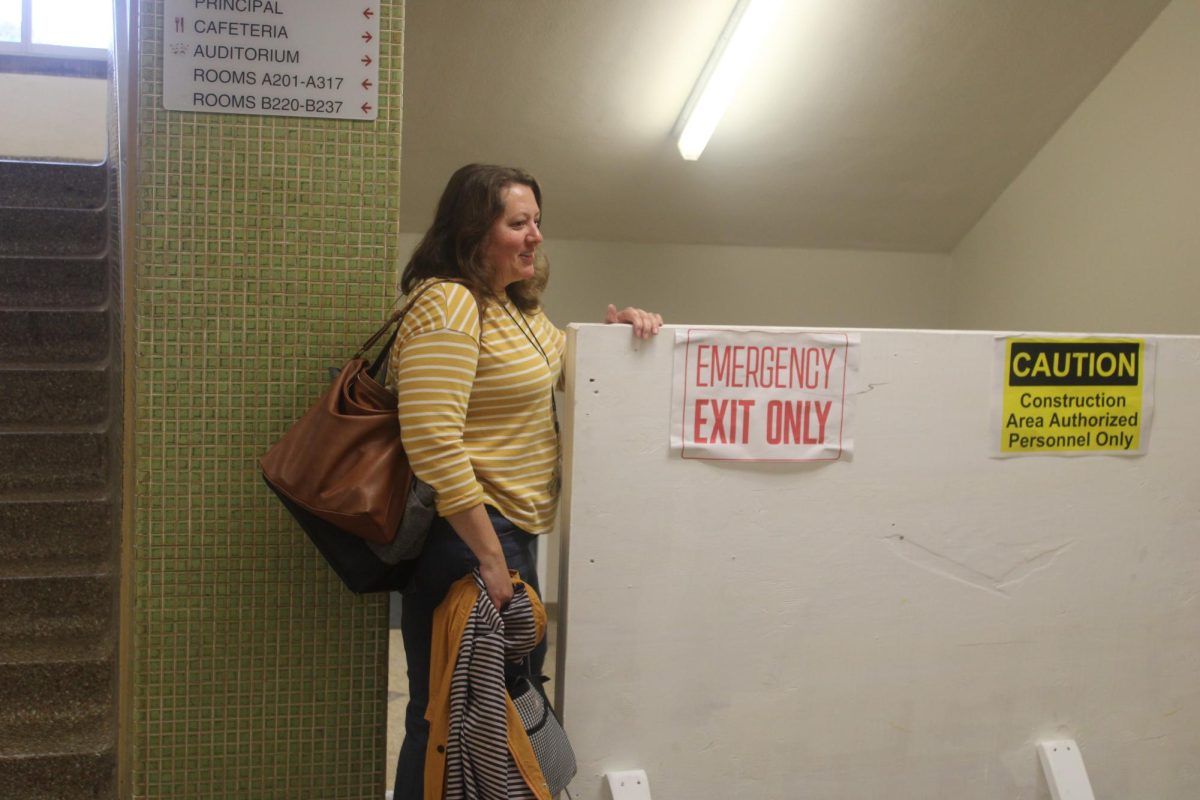 Theater director Jodi Schifsky walks past a closed off hallways leading to the auditorium and lunch room Sept. 29. The auditorium has been closed the entire school year due to construction on the lunch room. 
