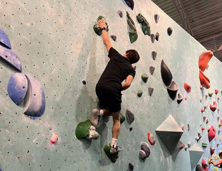 Junior Lucas Tangelson climbs rock wall on Nov. 24. Rock Climbing club meets Friday mornings.