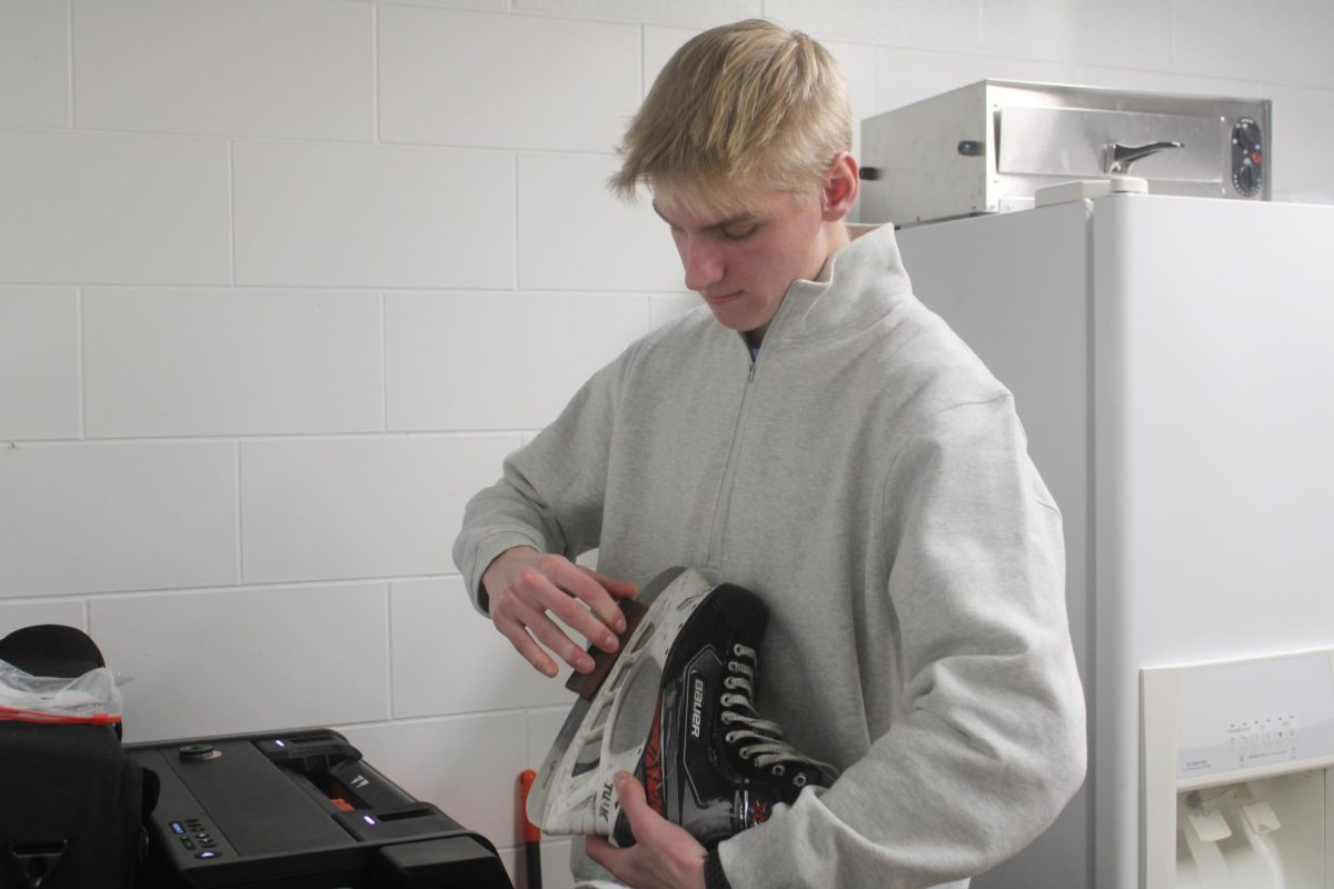 Senior Zack Nevinski sharpens a players skate. Through managing he will complete his 20 NHS hours.