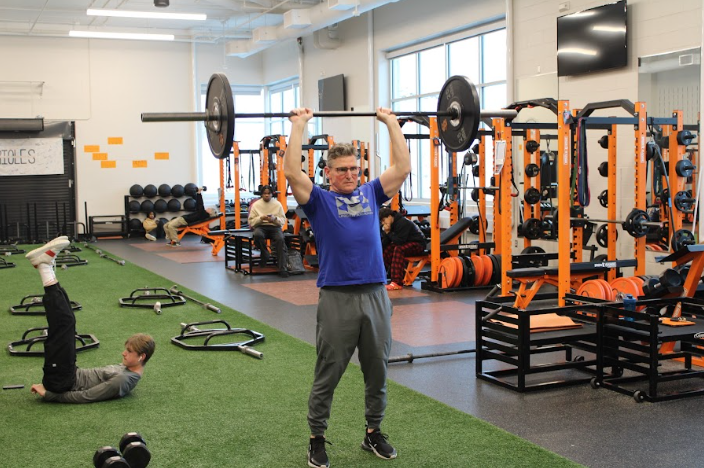 Physical education teacher Tim Donahue lifts weights above his head Jan. 2.  Physical engagement is a very popular New years resolution.