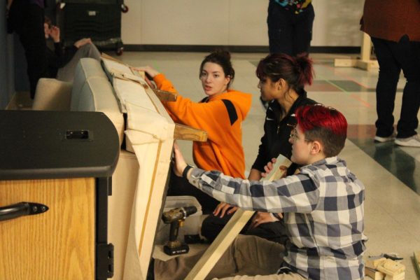 Juniors Kaylee Rice, Julia Lorenzen and Sid Bradley prepare for the upcoming theater competition on Jan. 23. They are fixing the couch in preparation for the showcase.