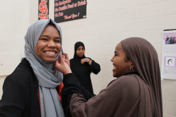 Sophomore Fethia Omer puts a hijab on junior Tamara Smith. World Hijab Day was celebrated during lunch on Feb. 1.