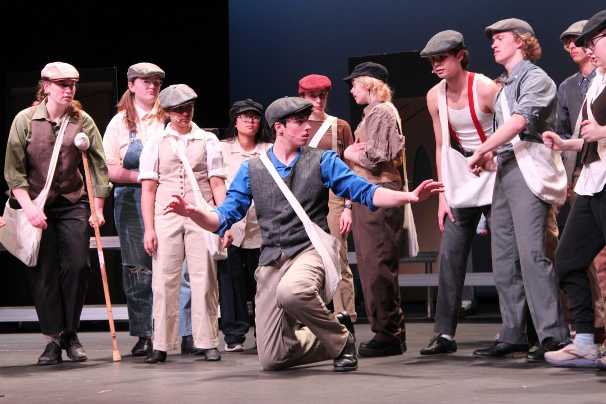 Junior Declan Gaines (Jack) performs center stage with other cast members in Newsies. The choir musical is done every year to raise money for their activities.
