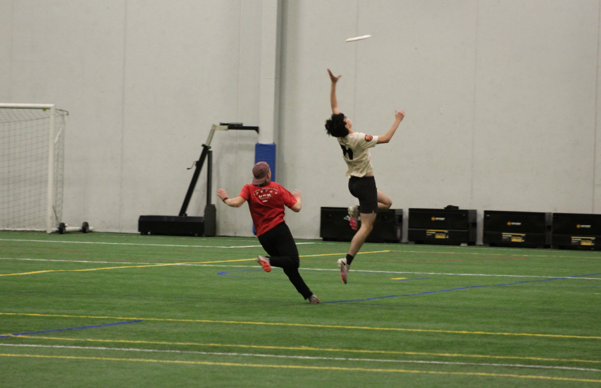 Senior+Saul+Zis+jumps+to+catch+the+pass++March+27.+Crush+ultimate+frisbee+wraps+up+their+tryouts+with+an+indoor+practice+at+Champions+Hall.