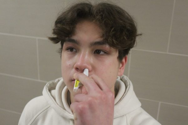 Sophmore Dominic Barth uses a demo Narcan nasal spray Feb. 15. The nasal spray can be found in the nurses office.