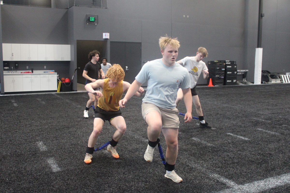 Junior Max Olson and other athletes warmup before their lift April 24. Football players workout at Gameface three times a week in the offseason.