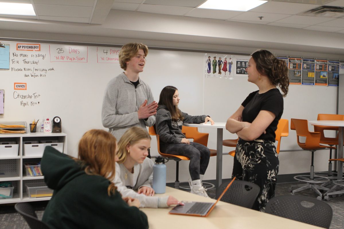 Senior Erik Lindell talks advisor Emily Rennhak at the student council meeting. The student council is planning for prom on May 11.