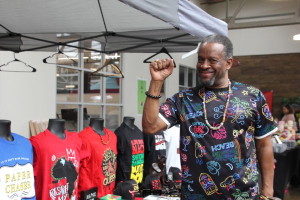 A stall owner at the Black Market sells black pride merchandise on April 13. The market was created to empower the Black community.
