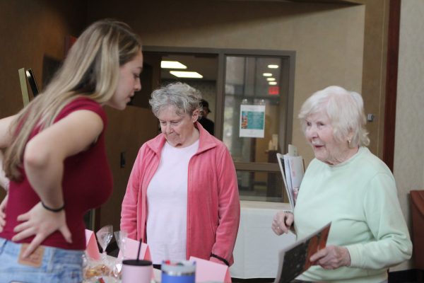 Senior Echo staffer Abby Meisler sells to Parkshore residents May 1. Echo held a bake sale to raise money to print newspapers.