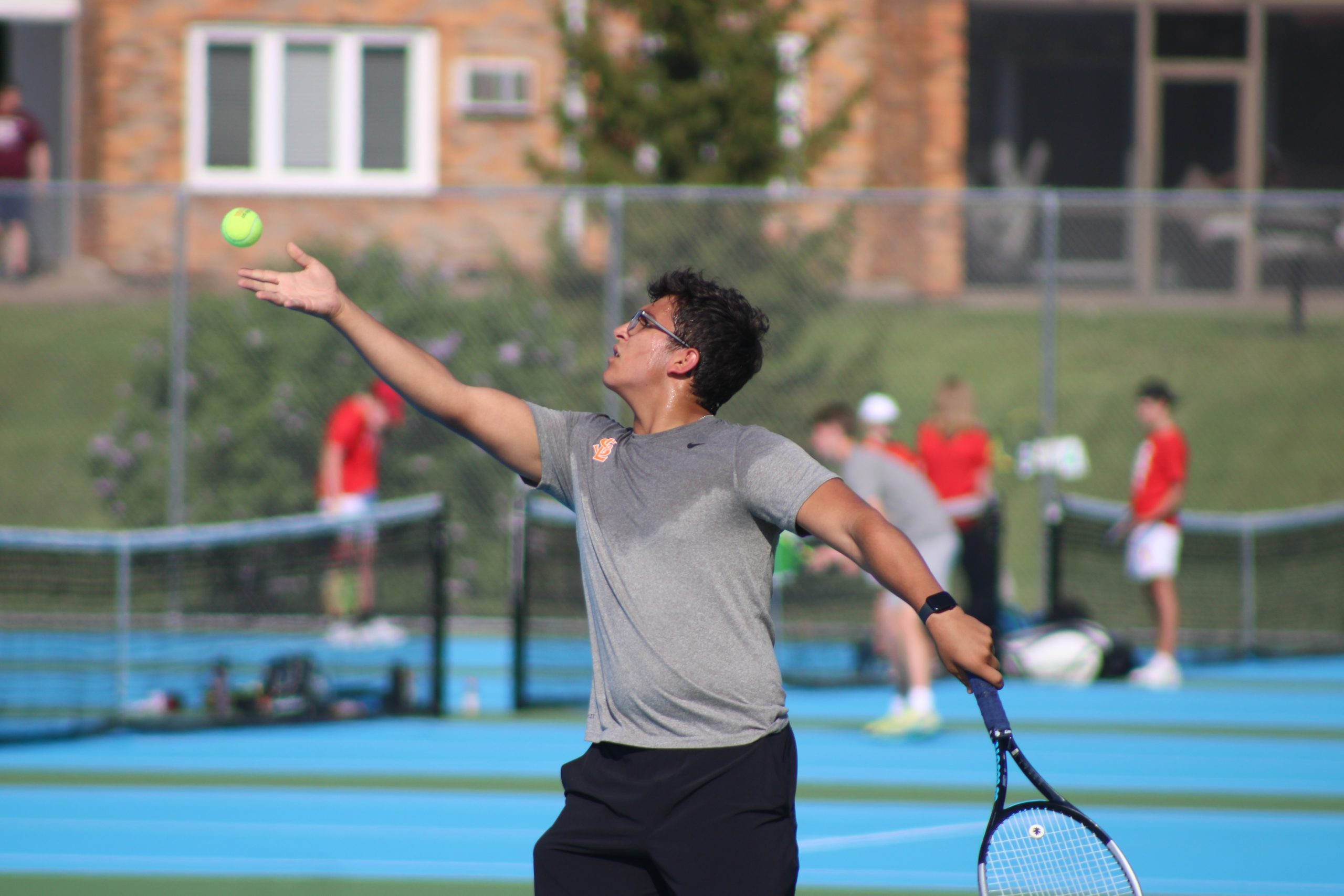 Junior Josh Fink prepares to serve the ball May 14. Fink ended up losing his match against Benilde St. Margaret’s at sections.