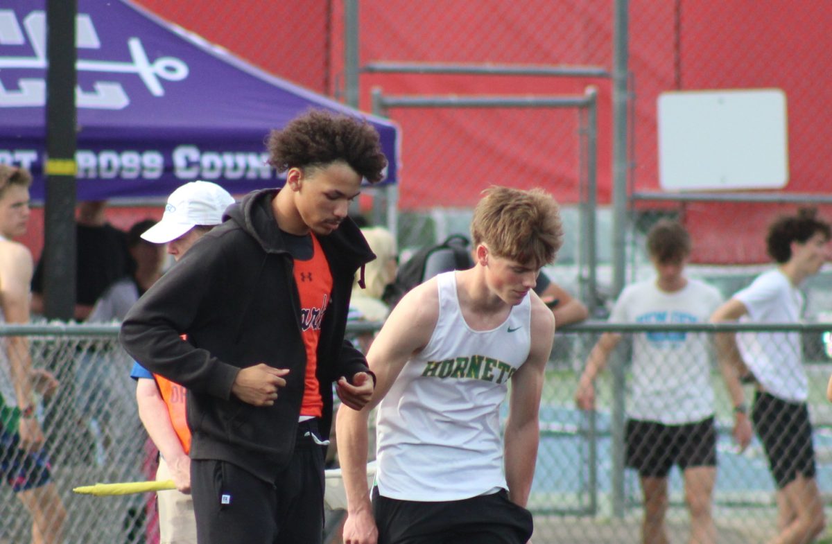 Junior Cordell Birden takes off his warmup jacket for the 100-meter dash May 30. Birden won the 200-meter heat and will compete in state next week.