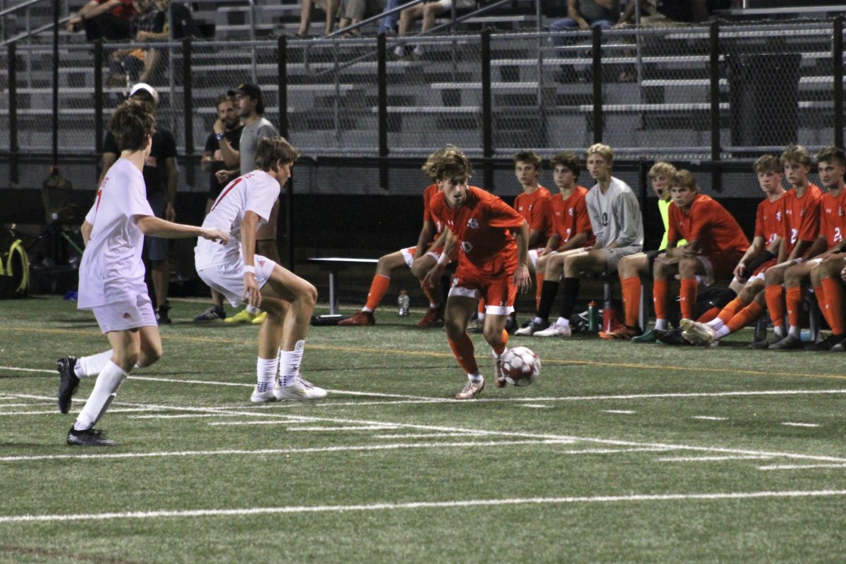 Senior Elijah Proost dribbles the ball past two defenders Sept. 16. The Orioles won 1-0 against Benilde St. Margarets.