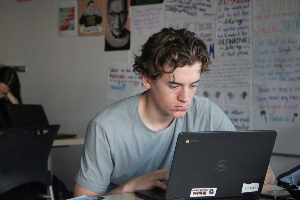 Junior Grant Haggerty works on his essay about Racial injustice in Colonial America in Ms. Merkele's IB America's class Oct. 22. Students in her class started writing after talking about Indigenous People's day on the holiday.