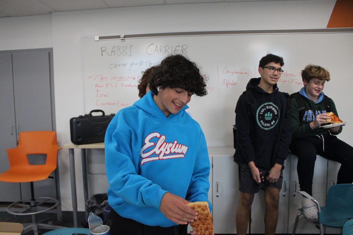 Junior Abe Percansky-Segal grabs a slice of pizza as JSU celebrates Sukkot Oct. 24. JSU meets every other Thursday.