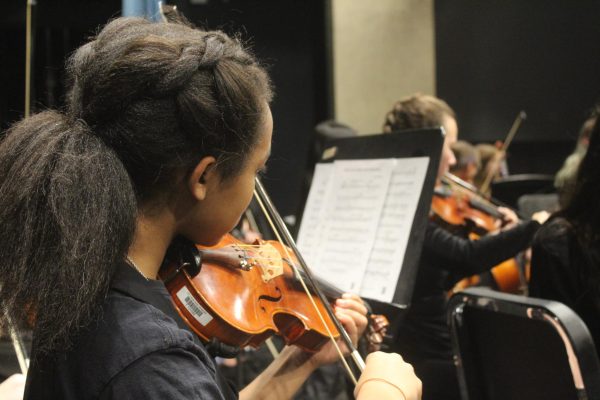 Sophomore Krychell Smith practices the violin during rehearsal. Orchestra members prepared to have their parts ready for the concert at 7pm Nov. 18.