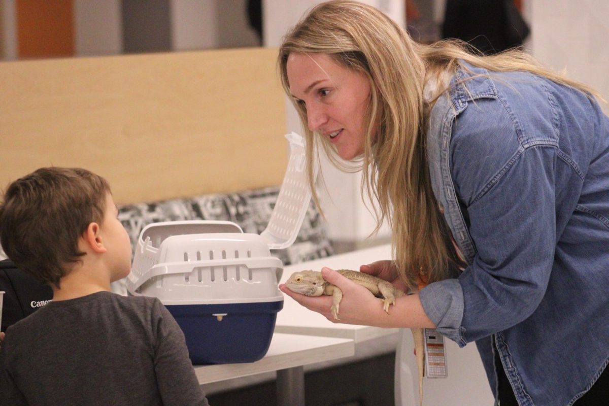 Science teacher Katherine Quatrinni shows the kids her class' pet bearded dragon at the family engagement night Park hosted on Nov. 21. Parents are able to get a closer look at what life is like for their students at Park.