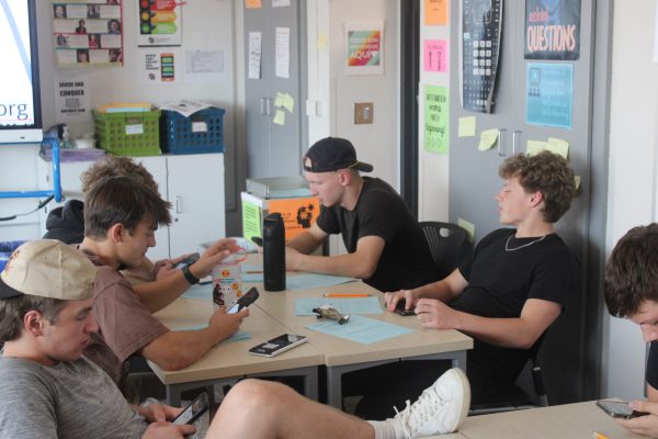 Seniors Jack Betzer and Lucas Tangelson play on their phones during class Oct. 22. As of the 2024-25 school year, Minnesota has made new legislation towards banning phones in schools.