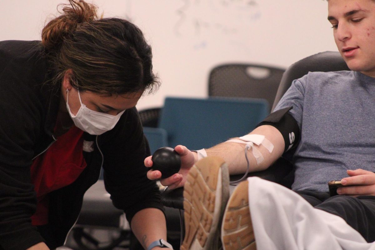 Senior Ari Rose donates blood to the Red Cross organization on Dec. 10. The nurses at the blood drive require anyone giving blood to hold and play with a stress ball to help promote blood flow.