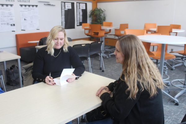 English Rose Suites representatives Heidi Swenson (left) and Jolynn Ericksen (right) talk with a Care Companions co-president Dec. 16. English Rose Suites is a memory care facility that Care Companions partners with to make playlists for their residents.