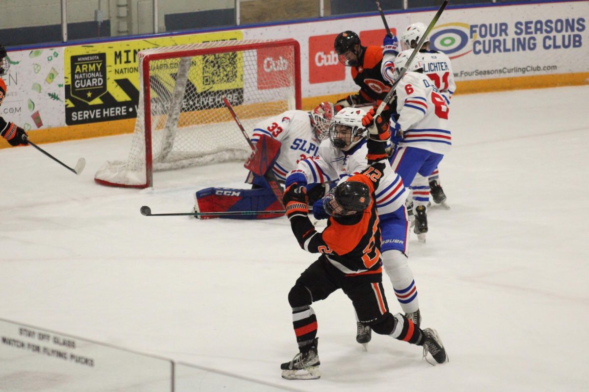 Senior left winger Brennan Hogan collides with a Spring Lake Park/Coon Rapids player on his way to the goal Dec. 3. Park finished the game with a 9-6 win after a 5-goal comeback.