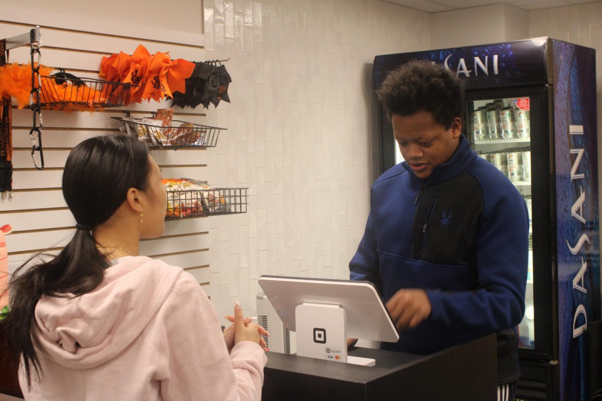 Senior Erek Bogucki sells products for the STORiole Jan. 15. Park's store has a lot of options from clothes to a quick snack.