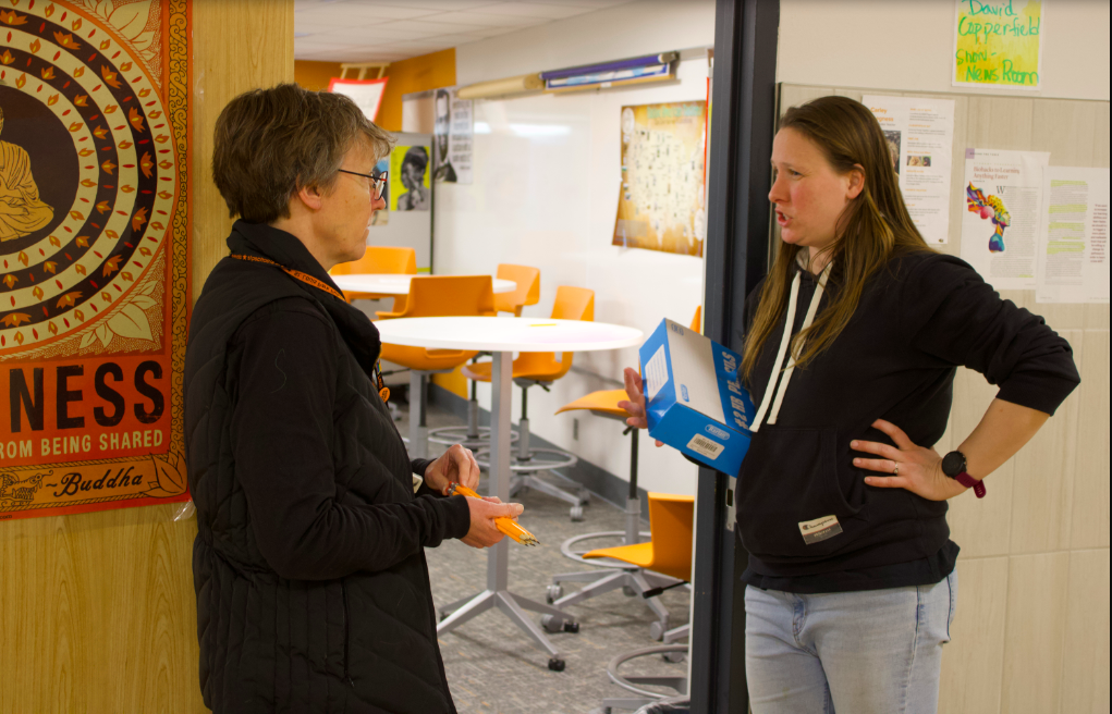 Social studies teachers Carley Kregness and Jill Merkle chatting in the hall during passing time Jan. 8. Both teachers wore black in solidarity of the Teacher Union.