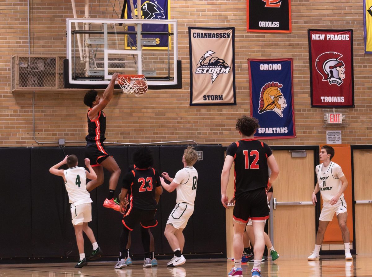 Senior Marley Curtis slam dunks the basketball against Holy Family Dec. 10. Boys basketball's successful season has attracted a higher student attendance.