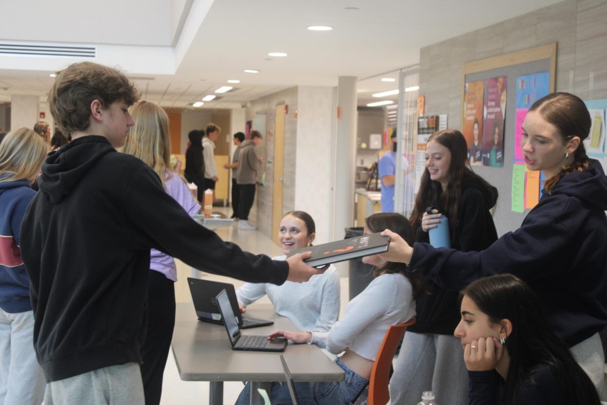 Sophomore Eli Tatalovich grabs his yearbook May 21. Yearbook distribution occurred during the lunch hours May 18-22.