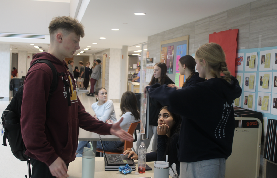 Senior Caedon Exsted reaches for a yearbook May 21. Echowan attends a yearbook camp every summer to pick out their fonts and color palette.