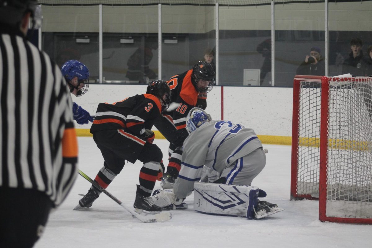 Sophomore Finn Rider and junior Leo Schmoll go in for a goal against the Hopkins goalie Jan. 8. Park took home the victory after an intense game against the Royals.