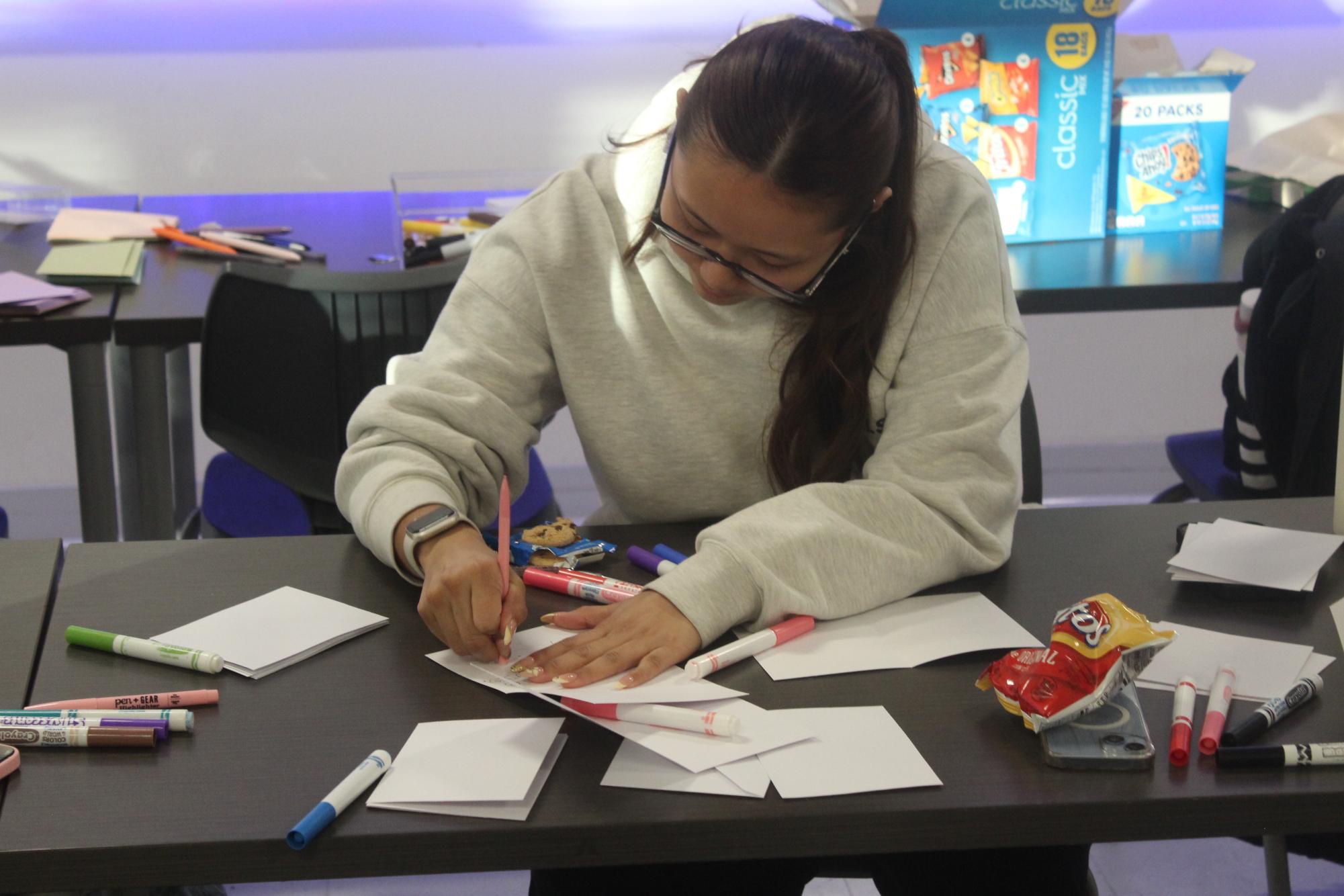 Junior Dolma Gyaltso writes letters to nursing homes in Health Occupation Students of America (HOSA) Jan. 7. HOSA is a club that focuses on expanding students' knowledge in the medical field and meets after school every Wednesday.