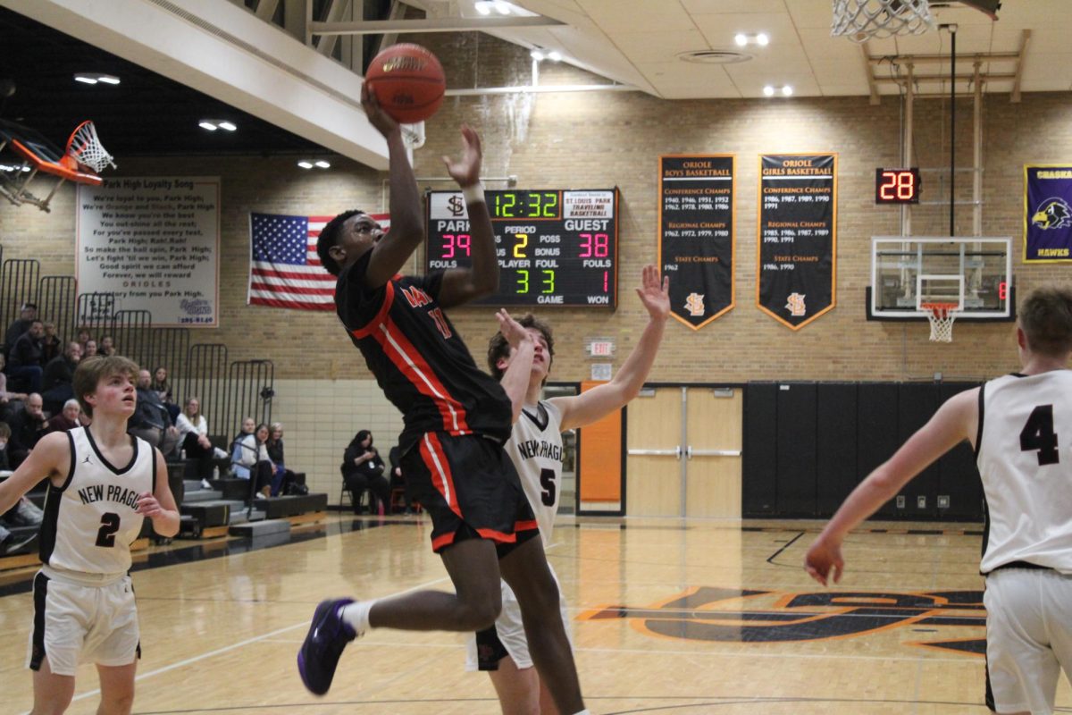 Junior Matthew Johnson leaps for a layup while guarded by a New Prague defender to extend Park's lead Feb. 12. Park lost the game, 56-65.