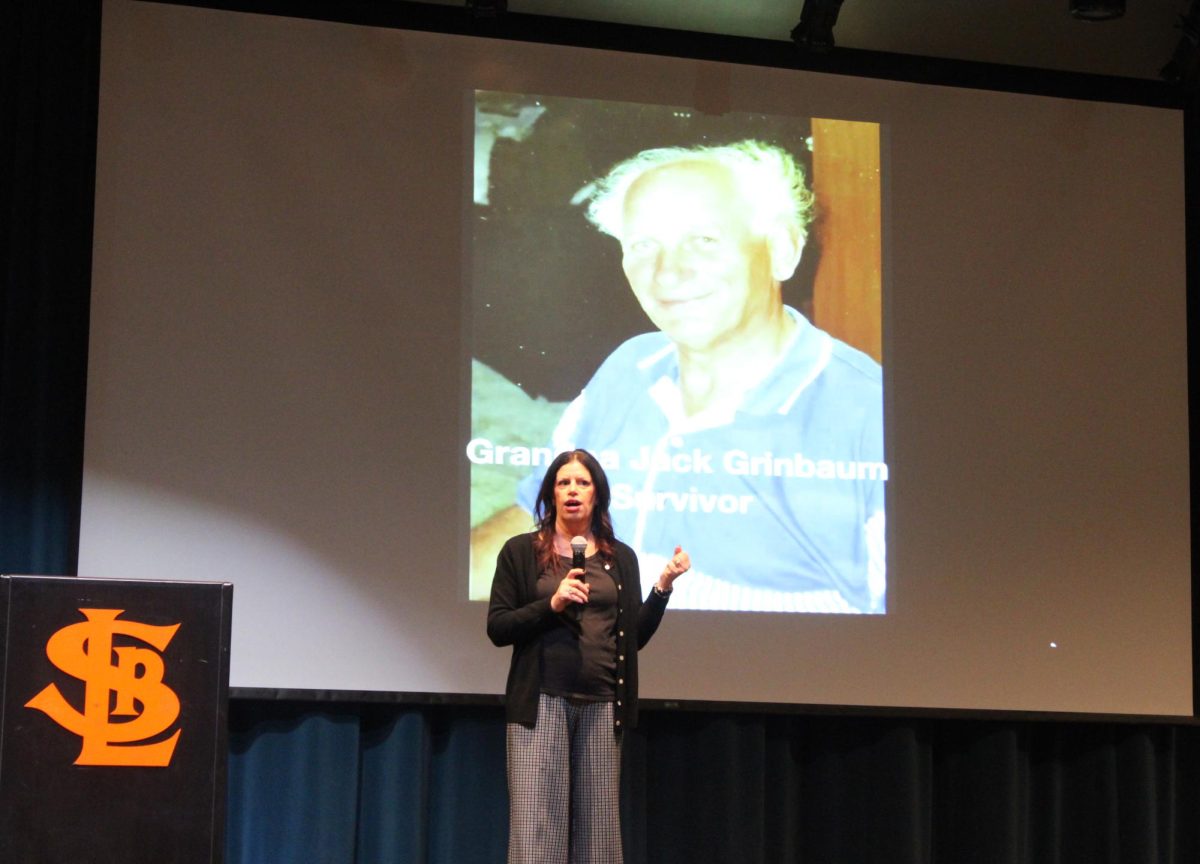Judi Shink speaking on remembering the history of the Holocaust and explaining the back story of Jack Grinbaum, March 11. By sharing the personal story of her grandfather, Shink emphasizes the importance of preserving first-hand accounts for future generations.