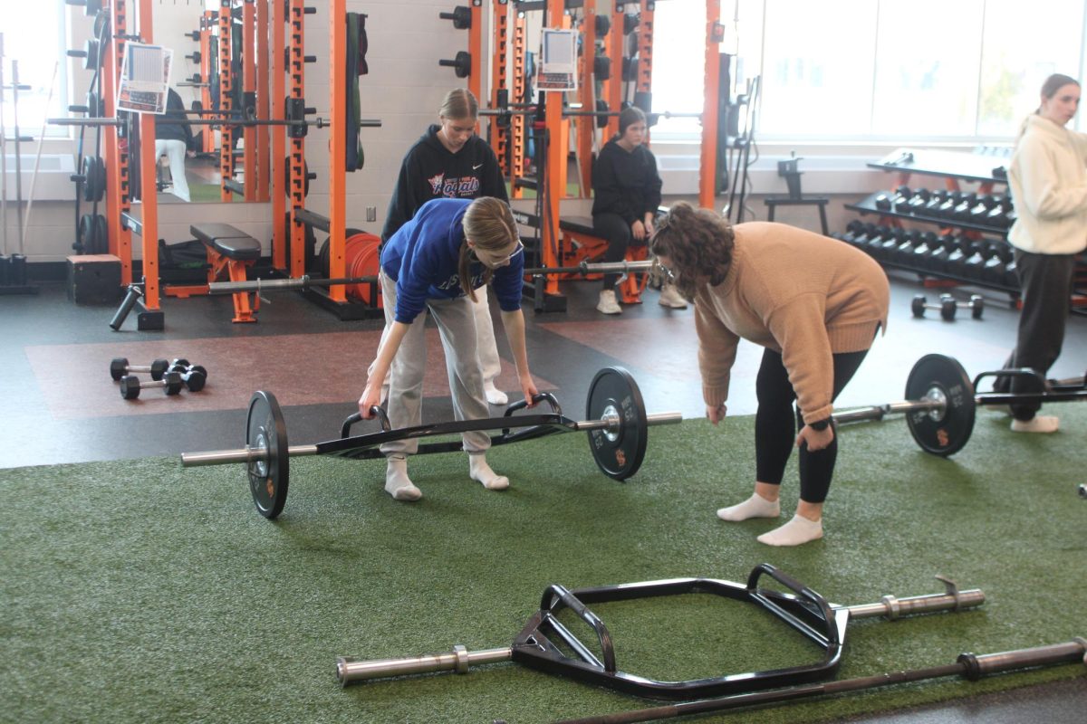 Coach Gust helps sophomore Ava Howell with her trap bar deadlift March 17. Gust helps athletes and other students with strength and conditioning before and after school.