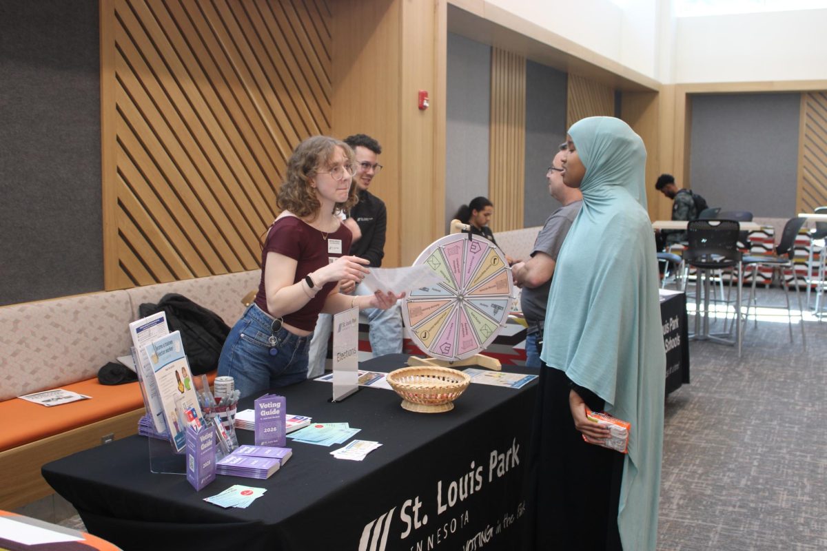 Student talks to a volunteer at the St. Louis Park elections table March 18. Students had the opportunity to talk to employees at different Park businesses at the career fair.