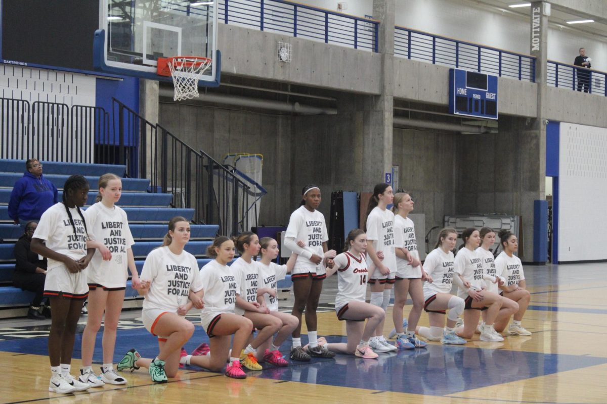 Parks’ girls basketball team kneels during the national anthem to protest inequality, Feb. 18. Park faced off against Hopkins Royals.