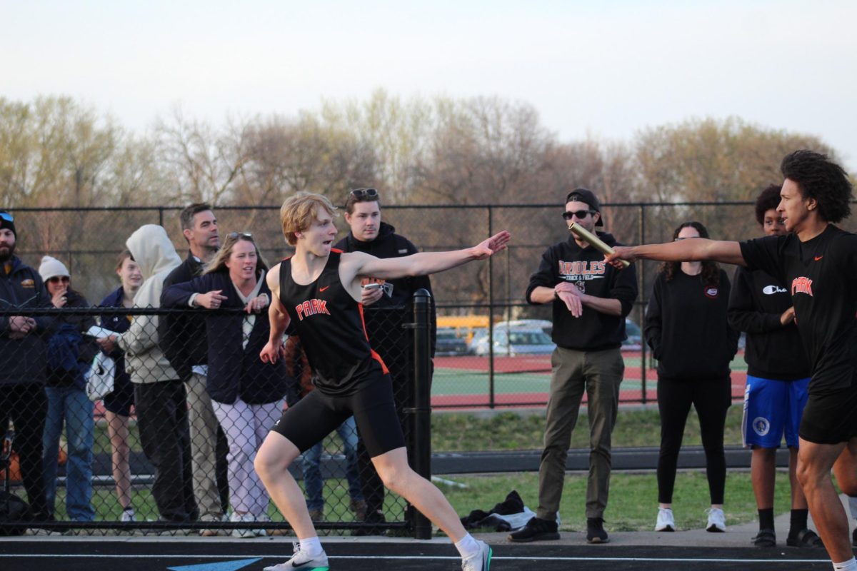Sophomore Charles Weaver and senior Miles Barto exchange the baton in the 4x400-meter relay April 20. Park finished first in the event among six other teams.