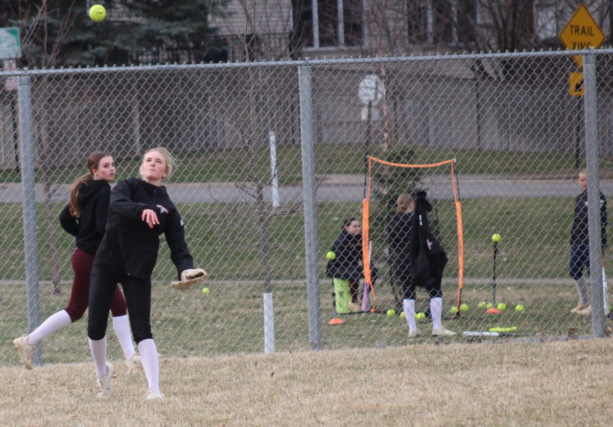 Sophomore Avery Dwight practices fielding ground balls with coach Gabler April 8. Players focus on charging the ball, using proper footwork to field on the glove side and dropping the throwing-side knee to transition into a quick throw.