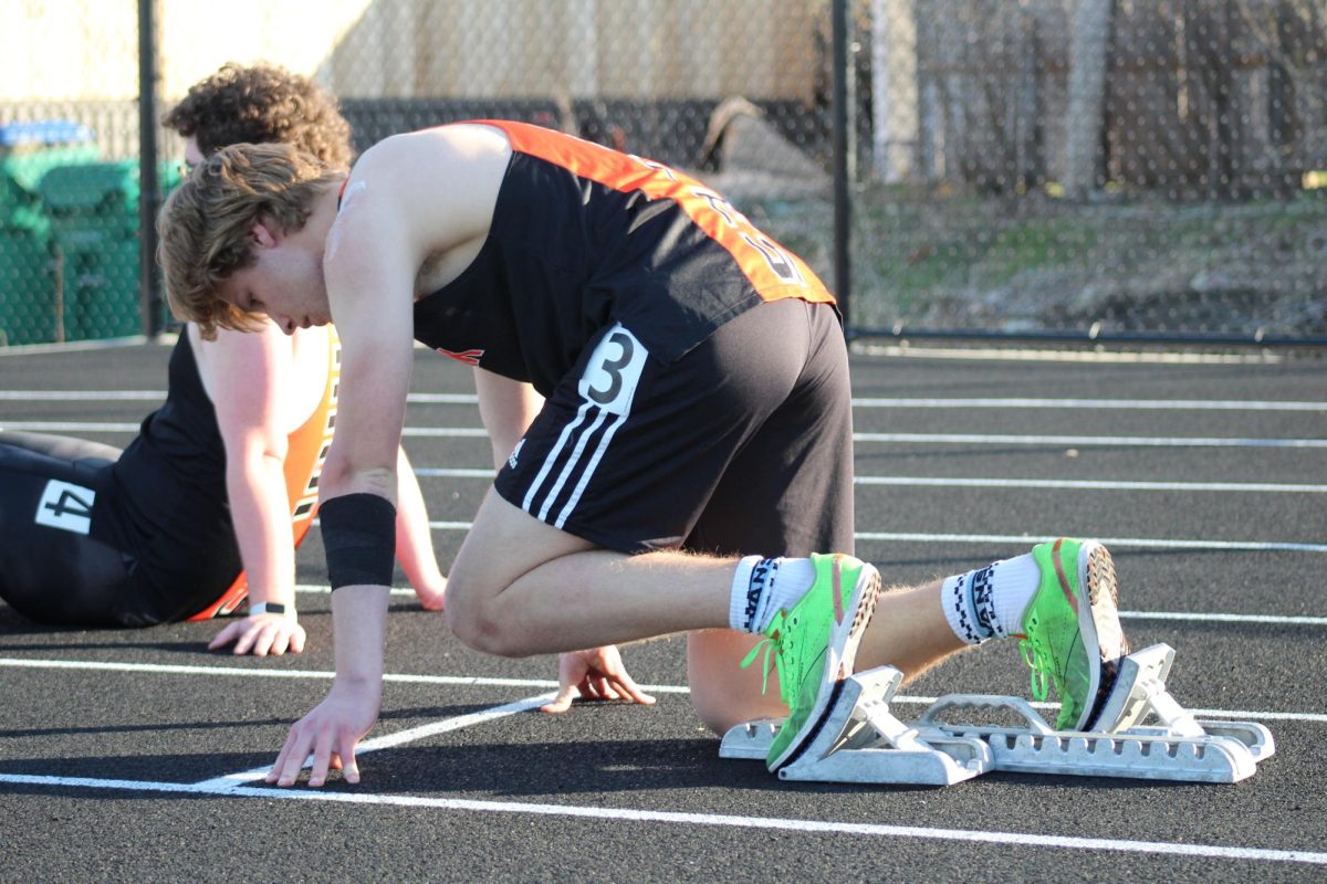 Sophomore Julian Bruns locks into the starting blocks for the 200m dash April 15. Bruns successfully set personal bests in three separate events at the meet, including the 4x200-meter relay and 4x400-meter relay.
