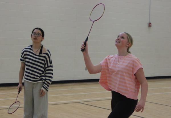 Freshmen Hadley Boesen and Lobsang Dolkar play doubles during a practice after school April 29. The badminton club has been doing informal double matches to practice working together and getting experience with playing.